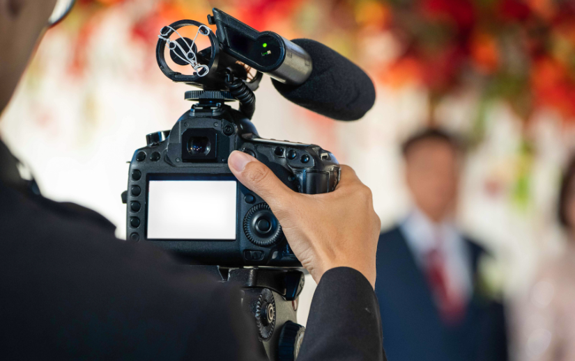 Close-up of a videographer recording an event, showcasing video creation opportunities for side gigs.